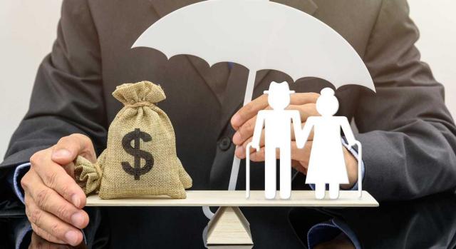 La aplicación de la normativa autonómica en el ISD por un contribuyente no residente es un derecho y no una opción. Imagen de la figura de un hombre en la que tiene una balanza en la que hay un saco con el símbolo del dolar, un paraguas y la imagen de unos abuelos